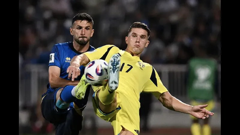 Cầu thủ Thụy Điển đang dẫn bóng qua cầu thủ Kosovo trong trận đấu bóng đá
