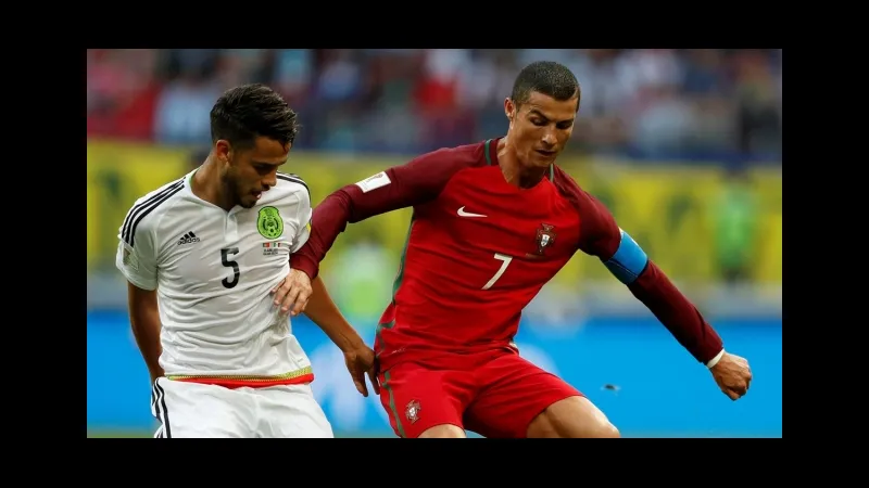 Cầu thủ Mexico và Bồ Đào Nha tranh chấp bóng trên sân cỏ